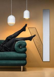 Editorial-kuva, jossa henkilö makaa sohvalla siten, että vain jalat näkyvät. Kuvassa myös kaksi lamppua ja peili.